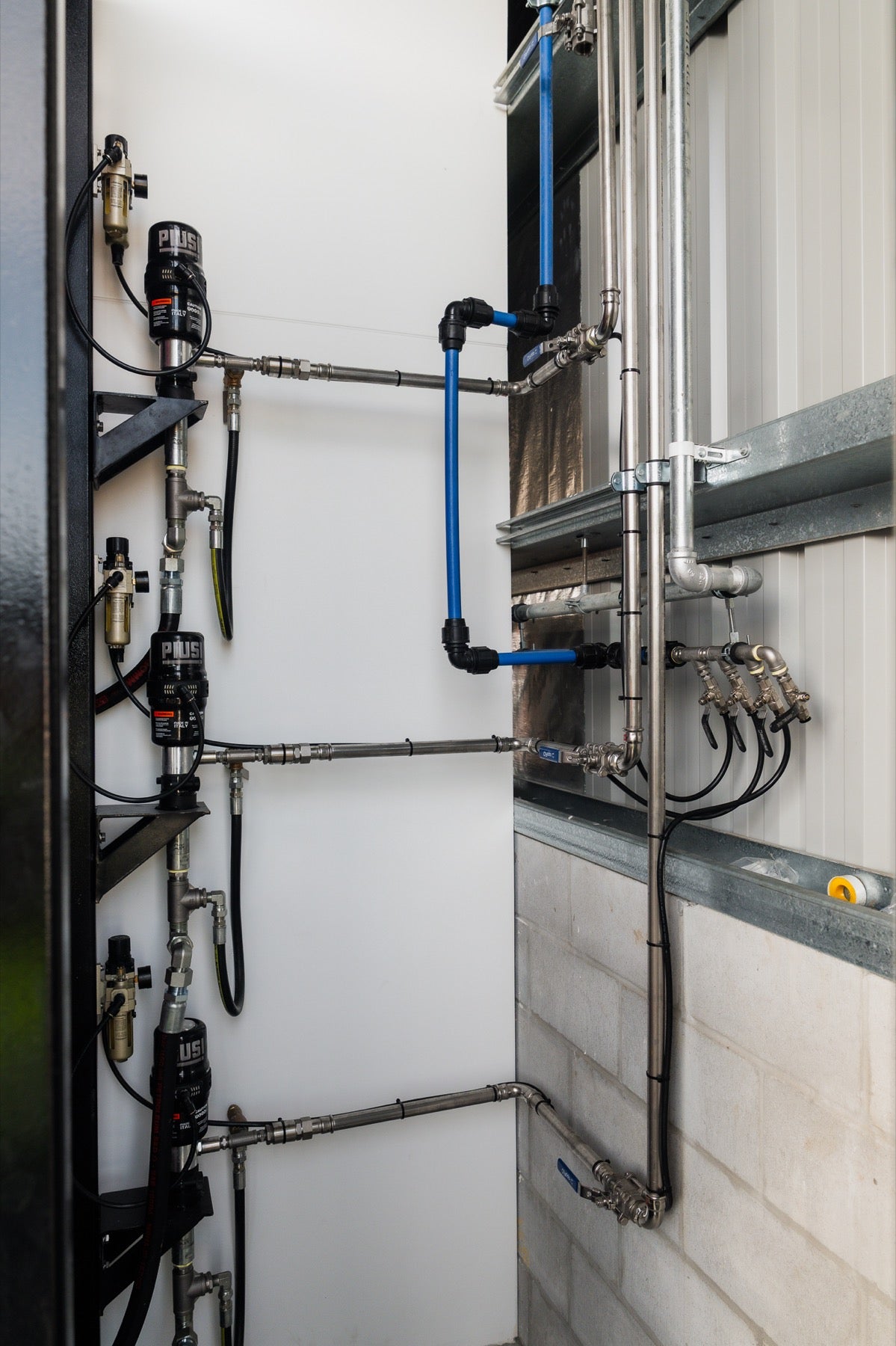 Wall-mounted Piusi pump station and piping